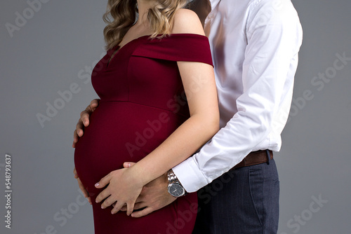 pregnant woman with her belly, pregnant couple posing in a studio