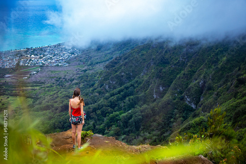 girl in pigtails stands at the top of the kuliouou ridge trail admiring the panorama of oahu, honolulu and the hawaiian mountains  hiking in the mountains in hawaii, holiday in hawaii © Jakub