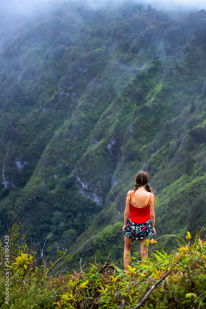 Fototapeta premium girl in pigtails stands at the top of the kuliouou ridge trail admiring the panorama of oahu, honolulu and the hawaiian mountains; hiking in the mountains in hawaii, holiday in hawaii