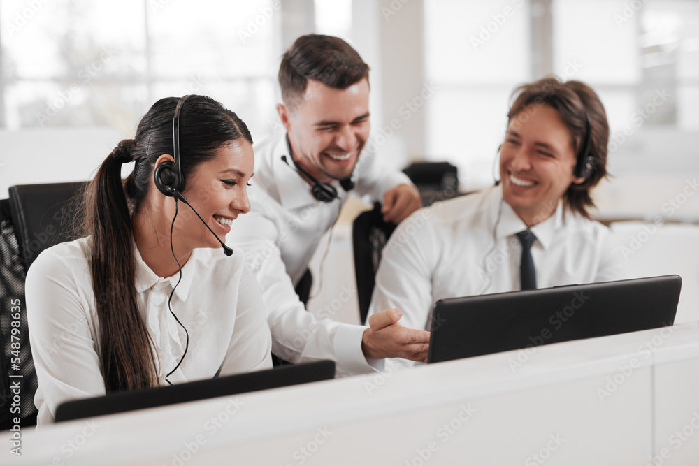 Call center workers discussing data on netbook Call center workers discussing data on netbook