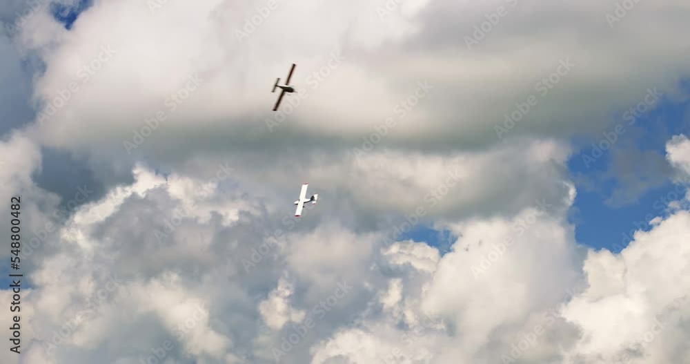 Classic light propeller planes flying in a sunny blue sky with white clouds Classic light propeller planes flying in a sunny blue sky with white clouds