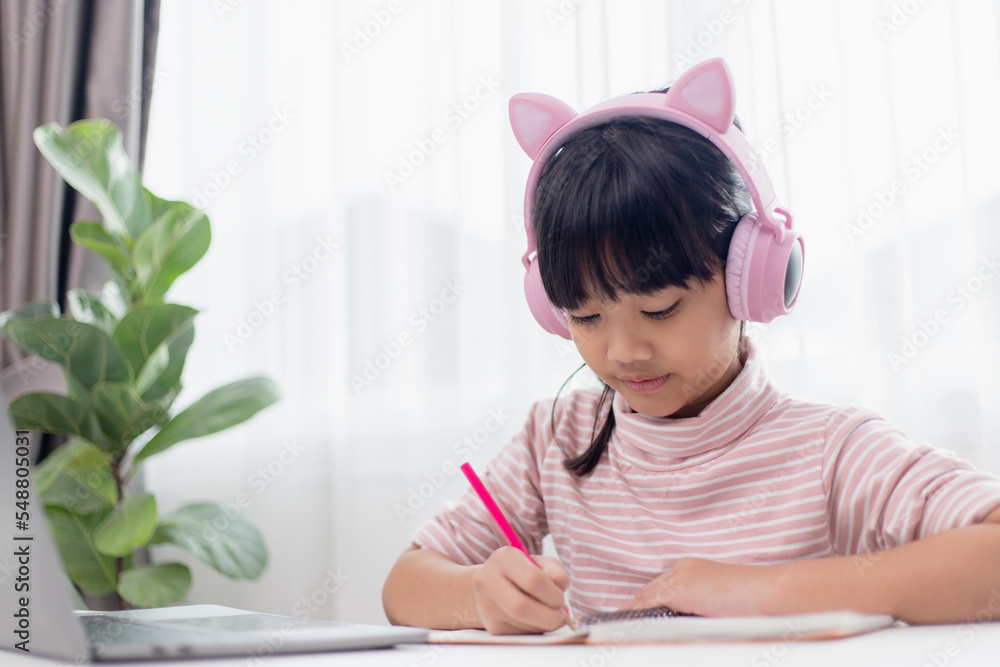 Asian little girl in headphones have video call distant class with teacher using laptop, study online on computer, homeschooling concept Asian little girl in headphones have video call distant class with teacher using laptop, study online on computer, homeschooling concept