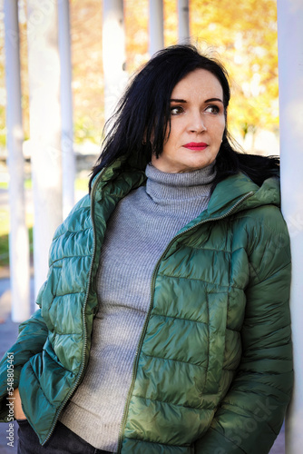 portrait of beautifful woman standing outdoors in green jacket photo