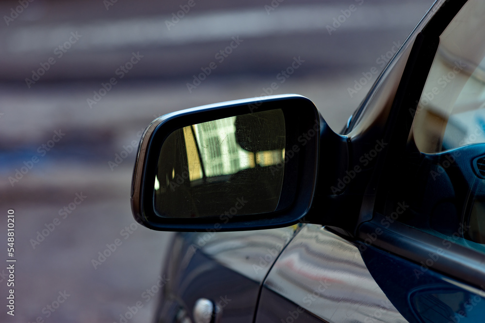 Macro shot to a side view mirror of a stationery car