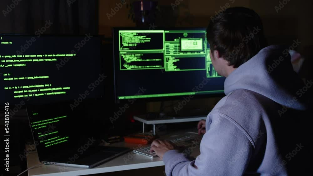 Young hacker, working and hacking with his computers. Attacking systems and danger computering. Young hacker, working and hacking with his computers. Attacking systems and danger computering.