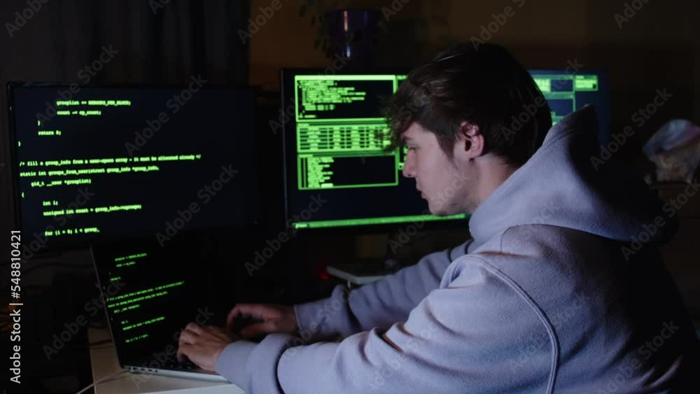 Young hacker, working and hacking with his computers. Attacking systems and danger computering. Young hacker, working and hacking with his computers. Attacking systems and danger computering.