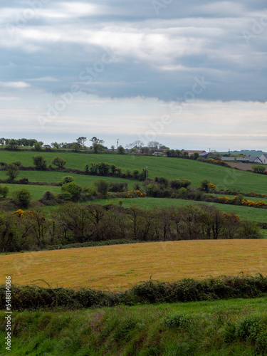 Picturesque Irish hills under a beautiful cloudy sky. Irish nature, spring landscape. Green grass field under clouds
