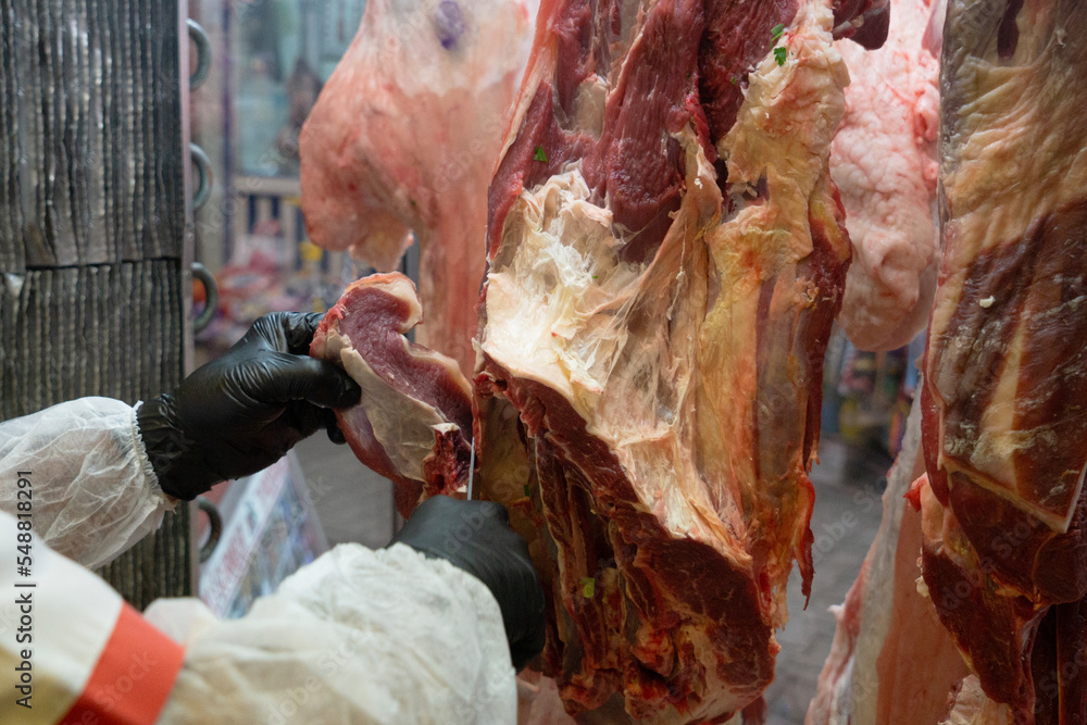 Cutting meat in butcher's shop