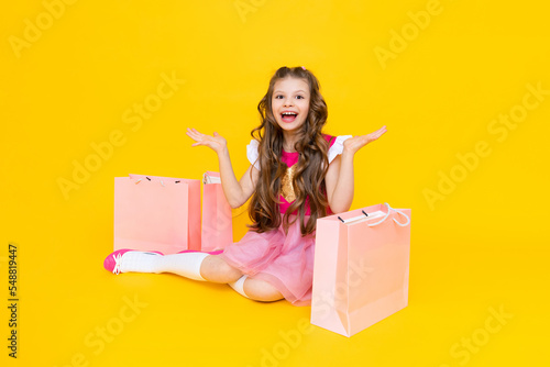 A little girl shopping after a big sale. Children's shopping. Gifts for children. Bags with clothes and shopping.