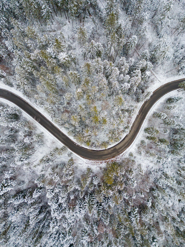 Photo from the drone. Winter landscape. Mountain winding road in a dense snow-covered forest. © Tomasz
