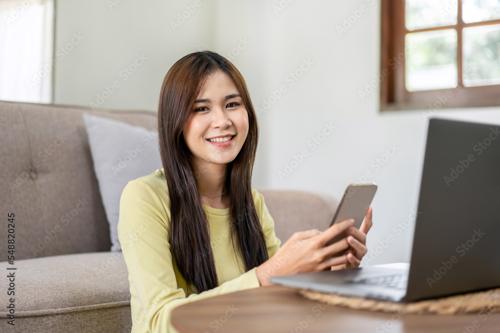 Young woman is sitting to smiling on the floor and using laptop to typing business report while working Young woman is sitting to smiling on the floor and using laptop to typing business report while working
