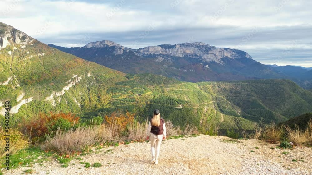 Young woman walking admiring the panoramic view from the Col de Rousset of the Vercors hills, the marly hills and the Val de Drome valley, France. Autumn View of the surrounding mountains and forests Young woman walking admiring the panoramic view from the Col de Rousset of the Vercors hills, the marly hills and the Val de Drome valley, France. Autumn View of the surrounding mountains and forests