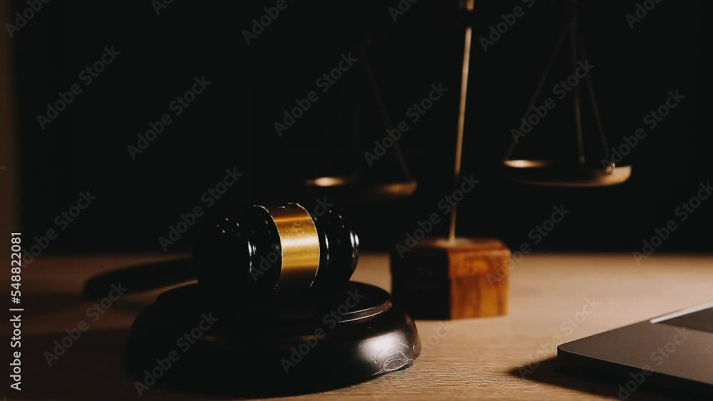 Justice and law concept.Male judge in a courtroom with the gavel, working with, computer and docking keyboard, eyeglasses, on table in morning light Justice and law concept.Male judge in a courtroom with the gavel, working with, computer and docking keyboard, eyeglasses, on table in morning light