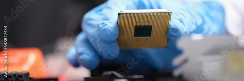 Engineer holds in hands powerful processor or board after repair