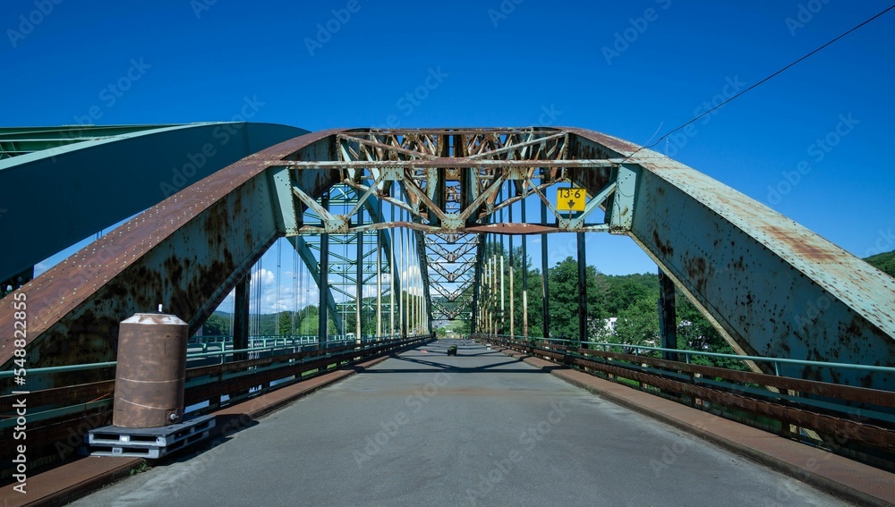 Steel arch bridge under a clear blue sky with some rust