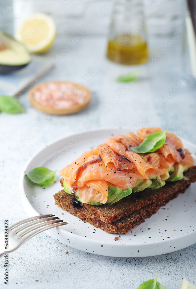 A rye bread sandwich with avocado and salmon