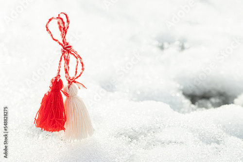 Martisor and Baba Marta. Symbols of spring. of rope on a snow background. Wallpaper of spring flowers and martenitsa.