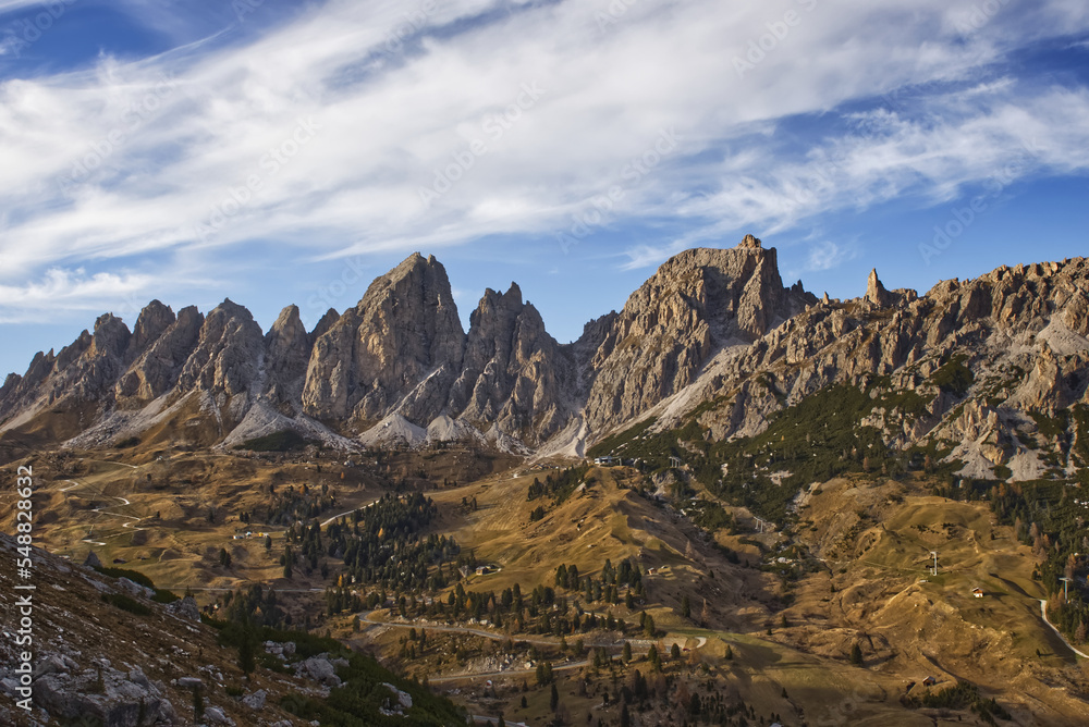 Alpine autumn landscape with mountains, blue cloudy sky