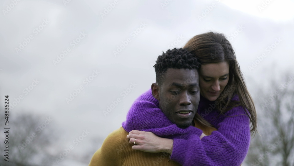 Boyfriend carrying girlfriend in back. Young millennial interracial couple, girl in man back Boyfriend carrying girlfriend in back. Young millennial interracial couple, girl in man back