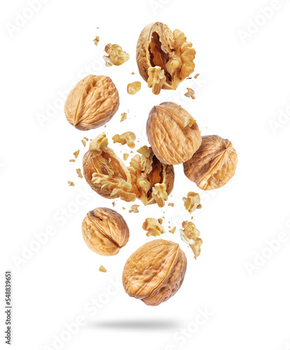 Whole and crushed walnuts close-up in the air on a white background photo