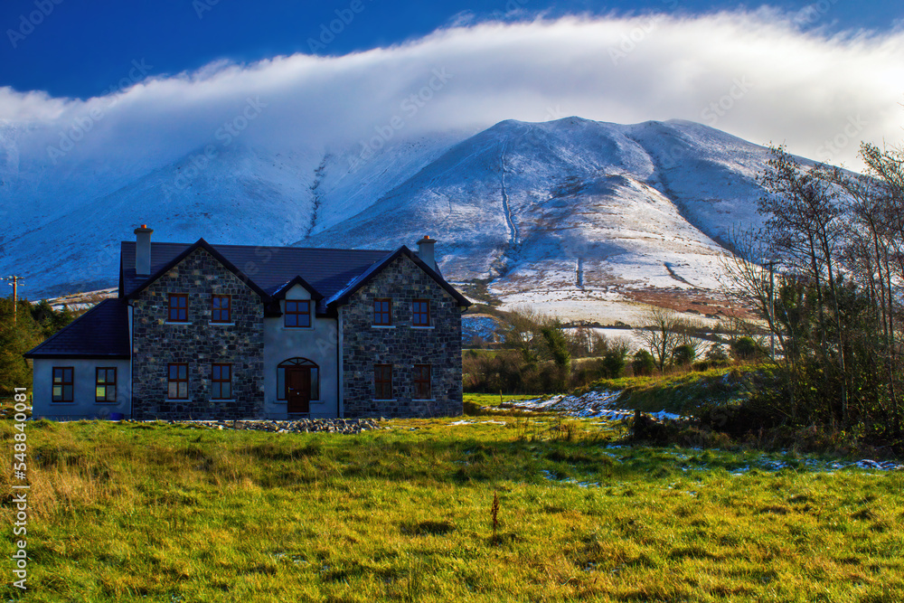 A country house on the background of snowy hills A country house on the background of snowy hills