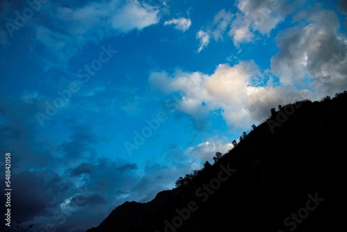 silhouette of a mountain at dusk with beautiful cloud sky © Erich