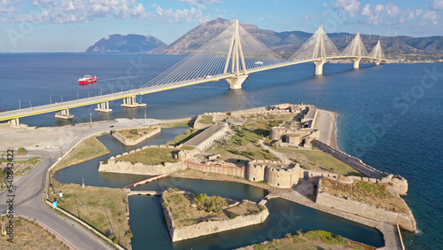 Aerial drone photo of iconic medieval ancient castle of Rio built next to modern cable strait bridge of Harilaos Trikoupis crossing corinthian Gulf, Central Greece photo