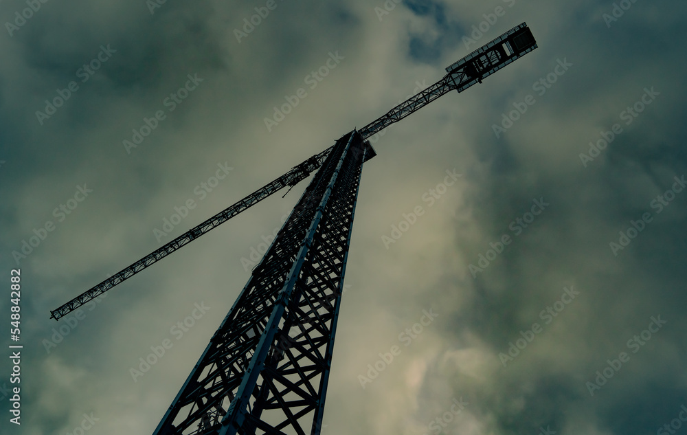 construction crane against cloudy sky. view from bottom