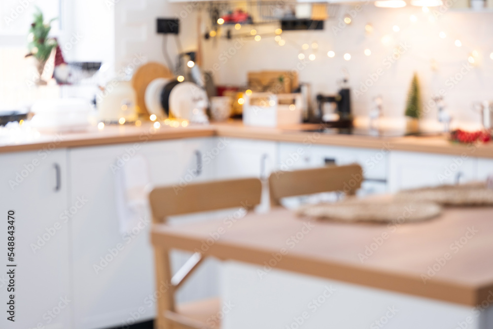 Interior background in a blur of white wooden kitchen of Festive Christmas decor and mess, festive breakfast, white scandi interior. New Year, mood, cozy home Interior background in a blur of white wooden kitchen of Festive Christmas decor and mess, festive breakfast, white scandi interior. New Year, mood, cozy home
