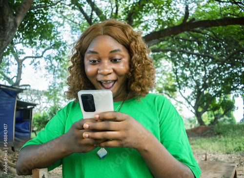 Excited African girl holding phone showing excitement emotions