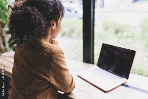 Young african woman working on her laptop in cafeteria. Over shoulder Free Download Young african woman working on her laptop in cafeteria. Over shoulder - GFXLoad