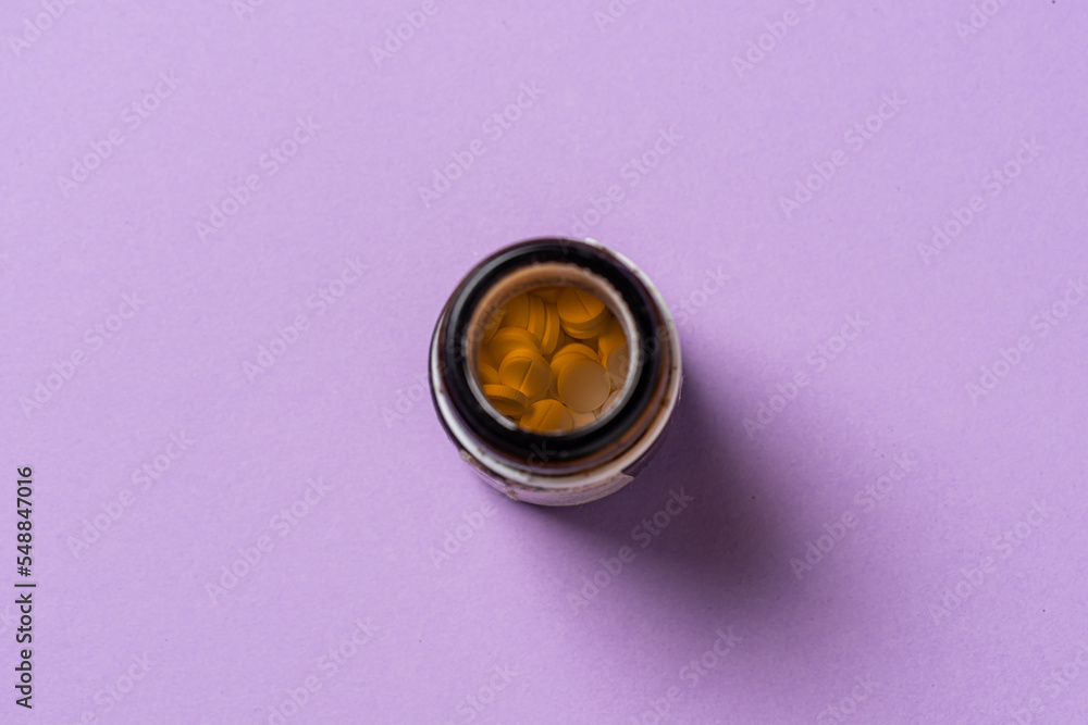 Small pills in a brown glass medicine pill bottle. Small pills in a brown glass medicine pill bottle.