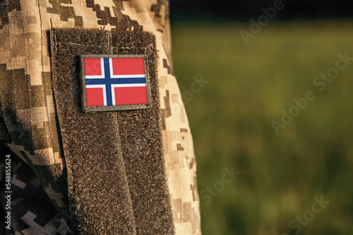 Close up millitary woman or man shoulder arm sleeve with Bouvet Island flag patch. Bouvet Island troops army, soldier camouflage uniform. Armed Forces, empty copy space for text
 photo