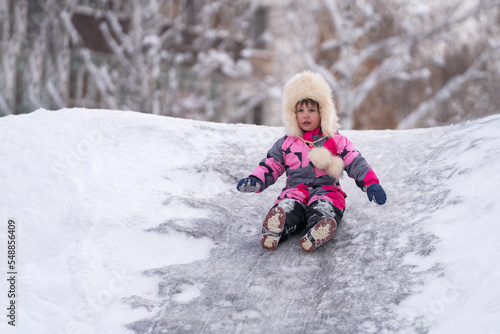 A child rides on an ice slide. Selective focus.