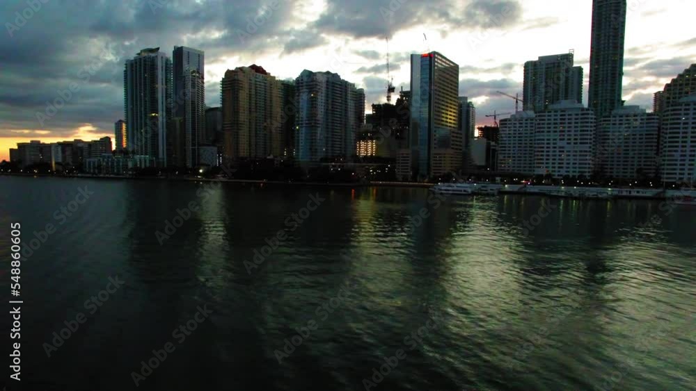 Aerial Panning Shot Of Modern Office Towers Under Cloudy Sky, Drone Flying Over Ocean During Sunset - Miami, Florida Aerial Panning Shot Of Modern Office Towers Under Cloudy Sky, Drone Flying Over Ocean During Sunset - Miami, Florida