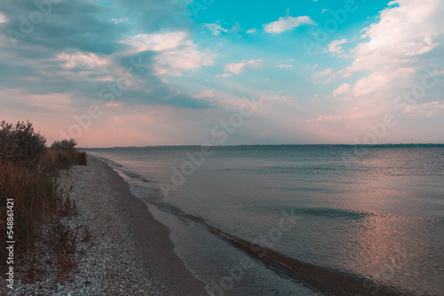 Amazing Black sea sunset. White   louds and water landscape. juicy blue sky. Golden blue hour at the ocean romantic evening. The sun reflects in the water. Horizon background and surf line.