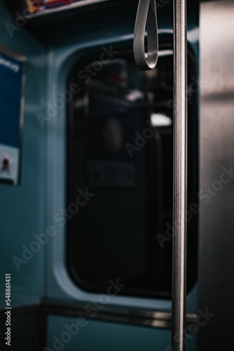 Vertical selective focus of a metal pole and bus handle captured in a train