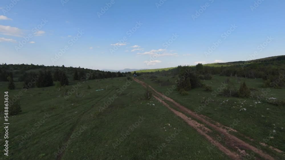Fast and maneuverable flight over the old country road in mountains with pine tree forest trees and beautiful sunset in the background. Filmed on FPV drone. Fast and maneuverable flight over the old country road in mountains with pine tree forest trees and beautiful sunset in the background. Filmed on FPV drone.