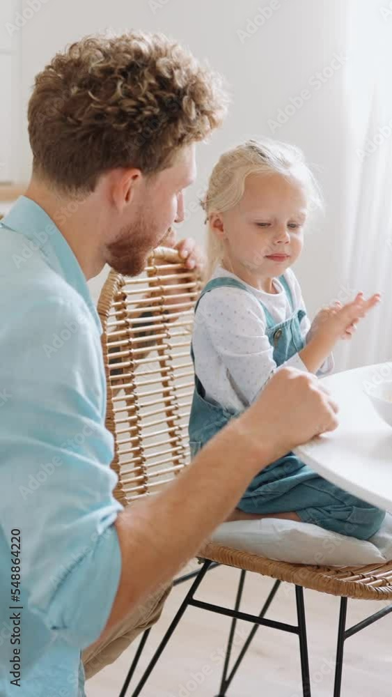 Positive father and daughter counting on fingers in the kitchen Positive father and daughter counting on fingers in the kitchen