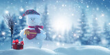 Merry Christmas and happy New Year greeting card with copy-space. Happy snowman with  red gift box  standing in Christmas landscape. Snow background. Winter fairytale.