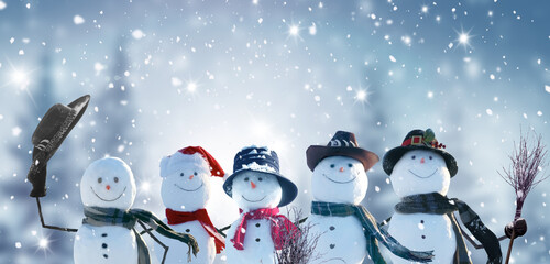 Merry Christmas and happy New Year greeting card with copy-space.Many snowmen standing in winter Christmas landscape.Winter background