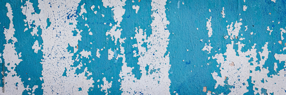 Peeling paint on the wall. Panorama of a concrete wall with old cracked flaking paint. Weathered rough painted surface with patterns of cracks and peeling. Panoramic texture for background and design. Peeling paint on the wall. Panorama of a concrete wall with old cracked flaking paint. Weathered rough painted surface with patterns of cracks and peeling. Panoramic texture for background and design.