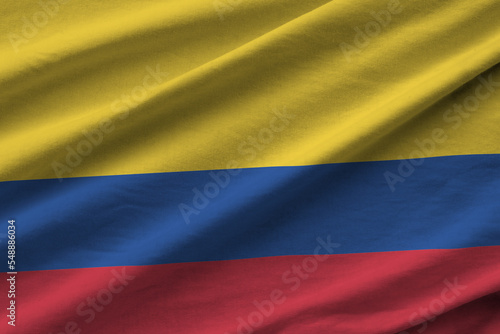 Colombia flag with big folds waving close up under the studio light indoors. The official symbols and colors in banner photo