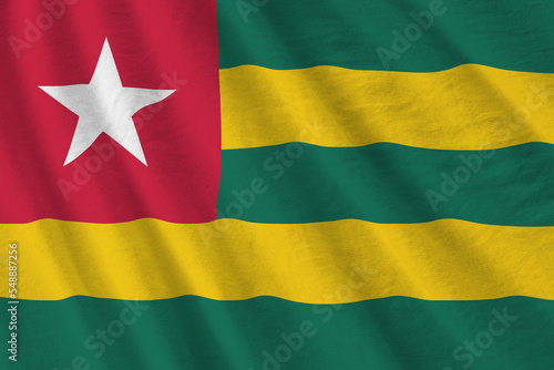 Togo flag with big folds waving close up under the studio light indoors. The official symbols and colors in banner photo