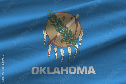 Oklahoma US state flag with big folds waving close up under the studio light indoors. The official symbols and colors in banner photo