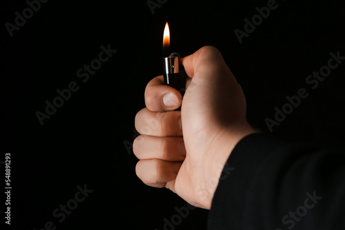 Man holding lighter on black background, closeup