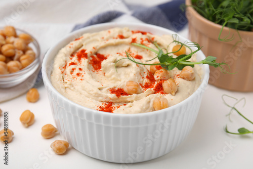Delicious hummus with chickpeas and paprika served on white table, closeup