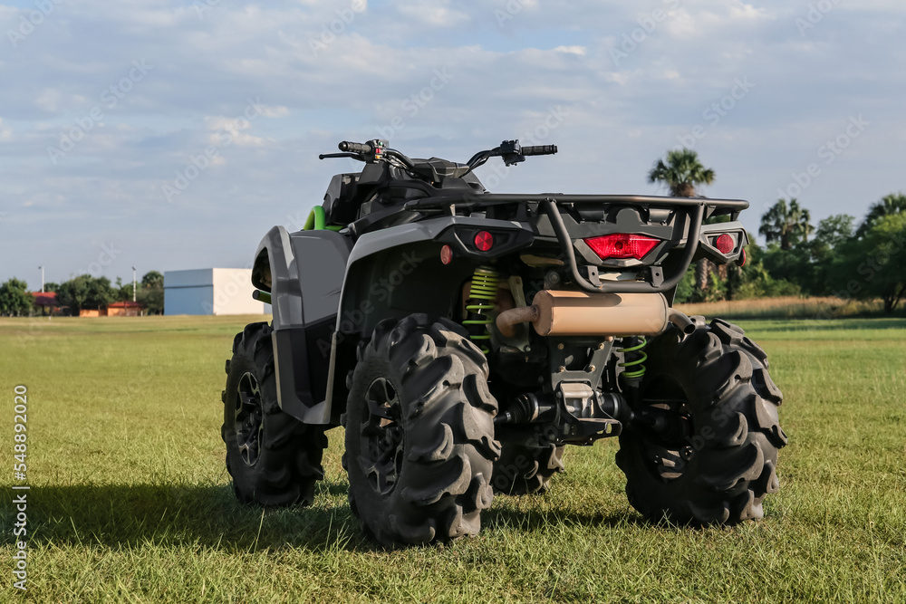 Obraz premium Modern quad bike in field on sunny day