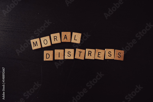 "Moral Distress" spelled out in wooden squares against a dark background.