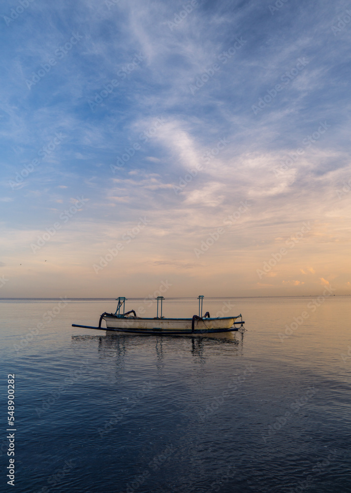 Beautiful morning around Lovina beach with traditional fisherman boats and blue sky as background.